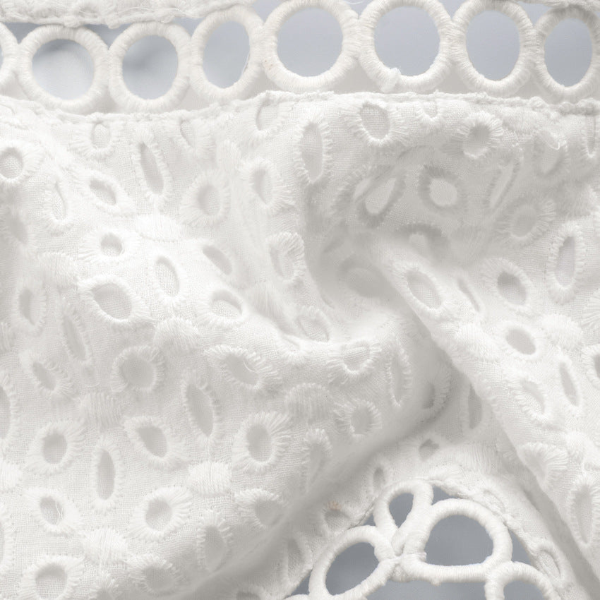Cami Crop Top in White Broderie Anglaise - white close-up of the broderie anglaise texture and circular hem trim