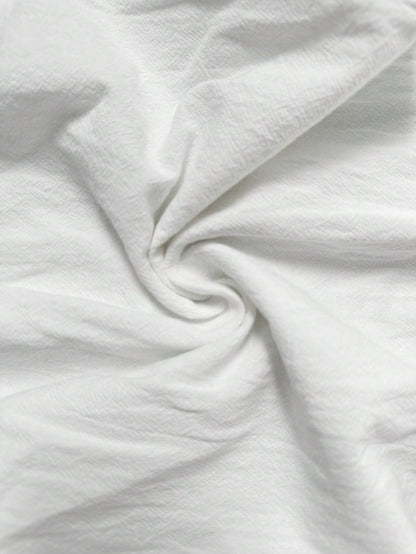 Wide-Leg Trousers in White Crinkle Cotton - white crinkle cotton texture close-up