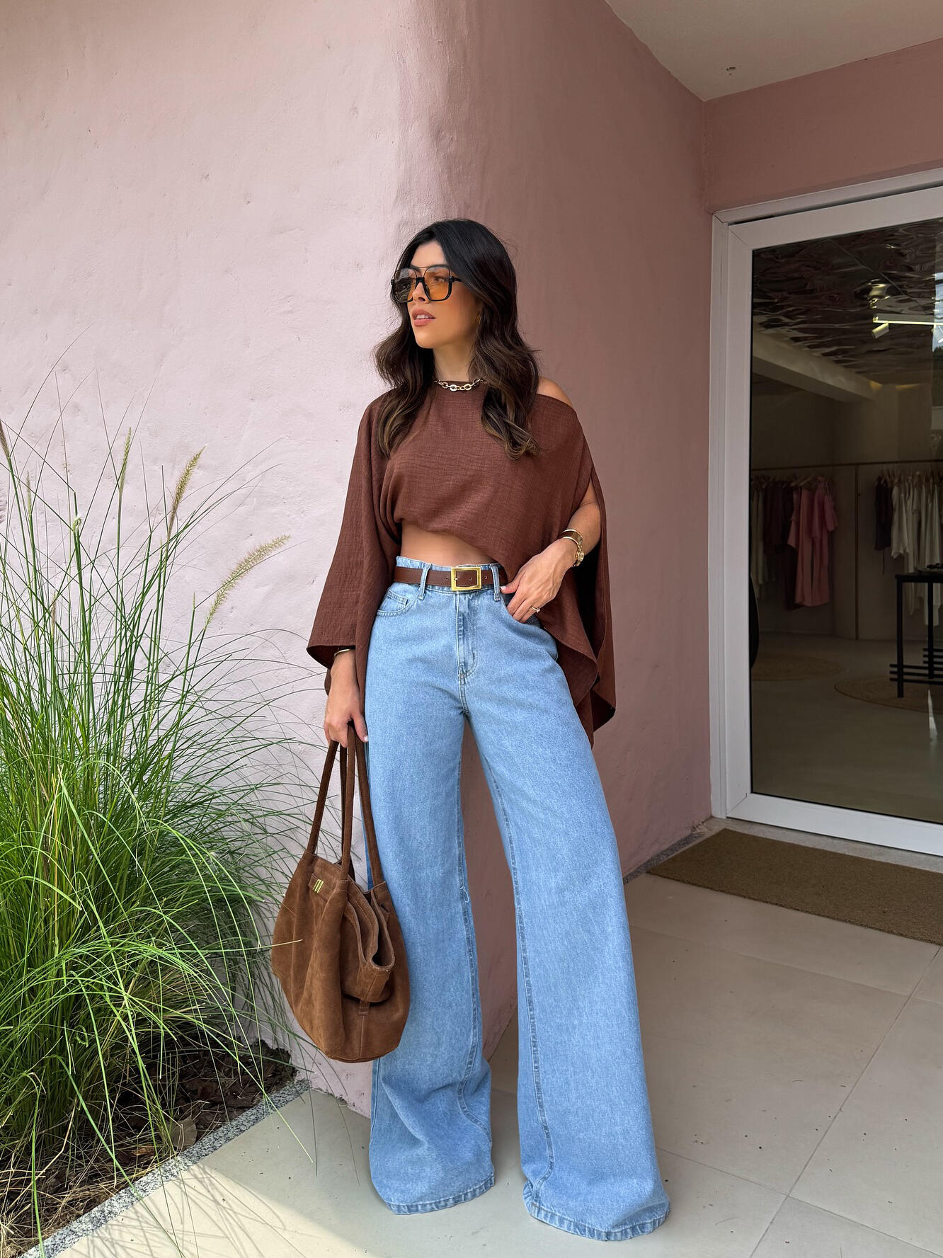Brown Asymmetric One-Shoulder Drape Top — full-length outdoor view with wide-leg jeans