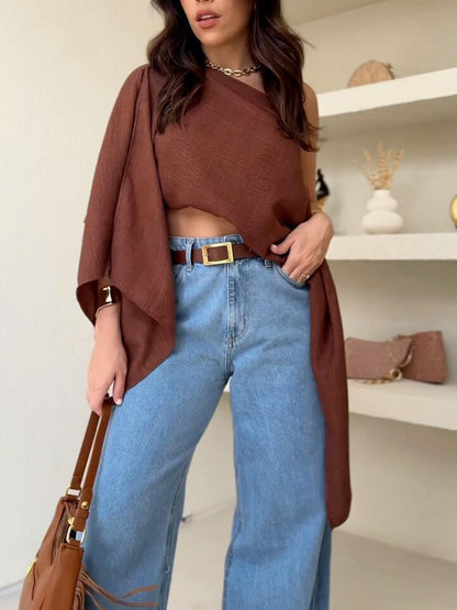 Brown Asymmetric One-Shoulder Drape Top — front view styled with light blue jeans and brown belt