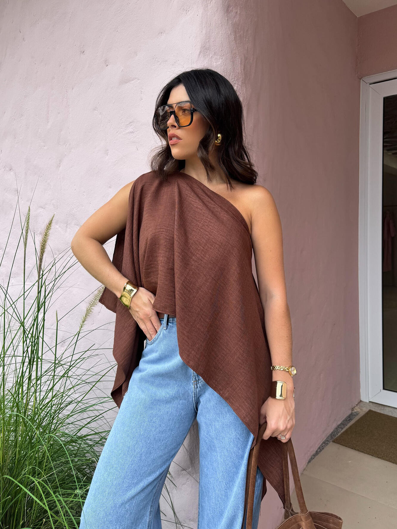 Brown Asymmetric One-Shoulder Drape Top — outdoor lifestyle shot showing the bare-shoulder side