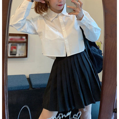 Shirt in White with Cropped Boxy Fit - white front mirror view with black pleated skirt